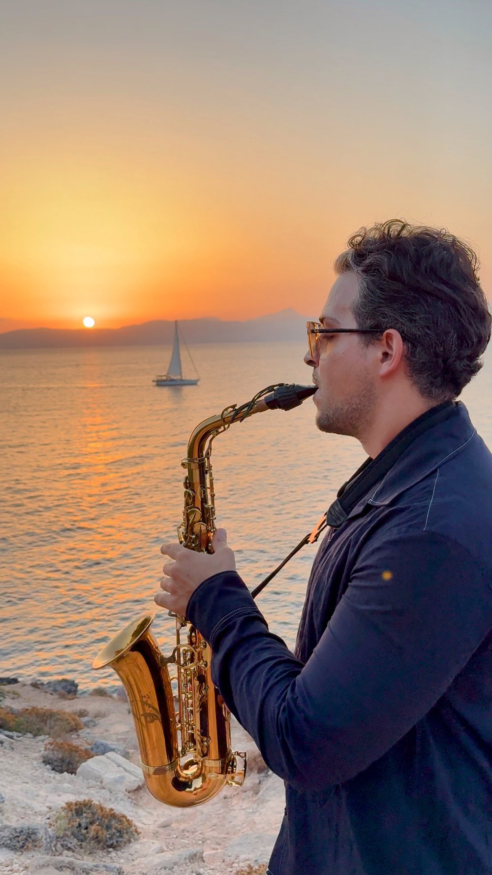 Rodrigo Belga playing saxophone at sunset by the sea