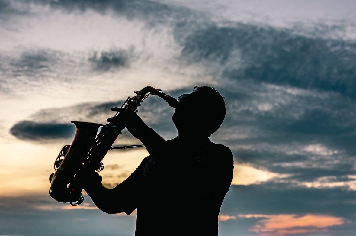 Rodrigo Belga playing saxophone, silhouette at sunset